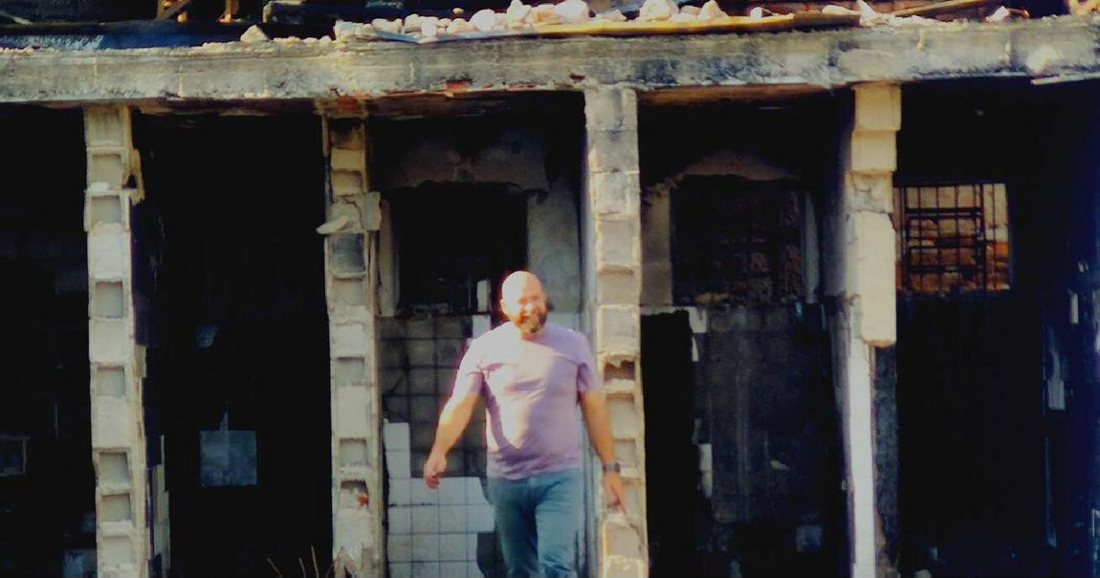 O fundador caminhando na estrutura destruída pelo incêndio